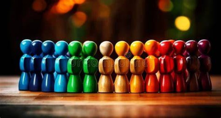 a group of multi colored medical pills organized in a row directly above view on beige background