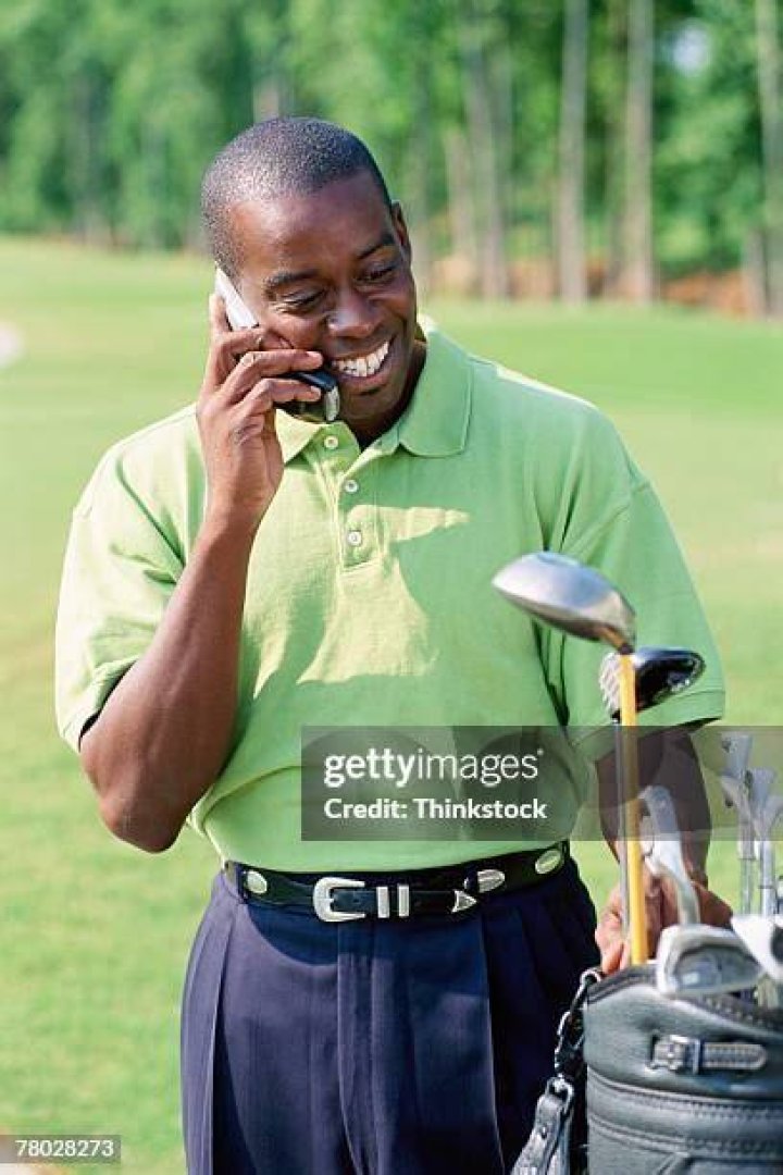 golfer using cell phone in indoor putting green