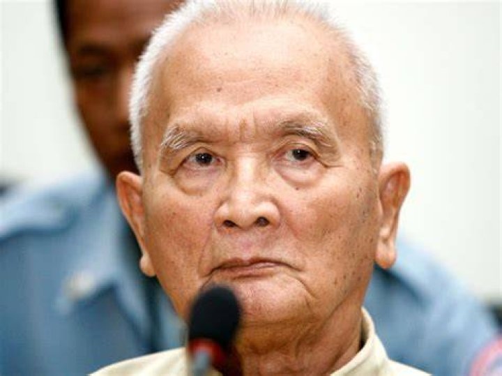 Nuon Chea's wife sits by the bed