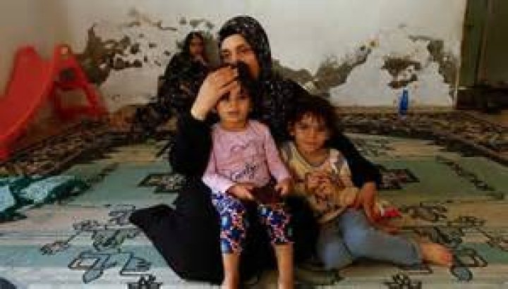 Palestinian woman Samah Abu Latifa, who fled her home amid Israeli strikes, shelters with her family in a kindergarten